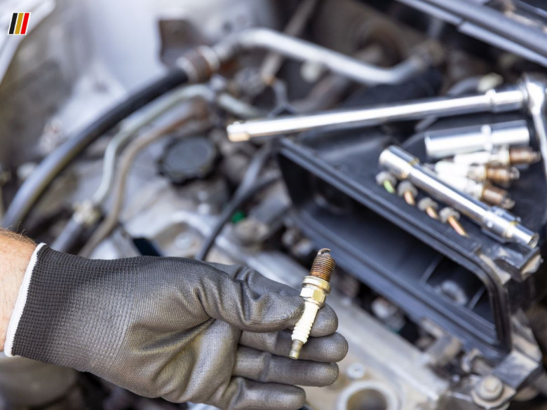 Mechanic holding a used fuel injector during car engine repair and replacement service
